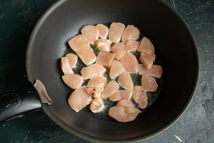Searing chicken breast pieces in a single layer in a skillet