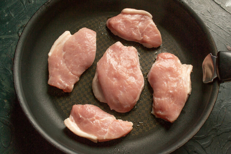Searing the meat Searing pork pieces in a hot skillet