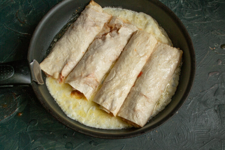 Frying lahmacun rolls seam-side down in a hot skillet