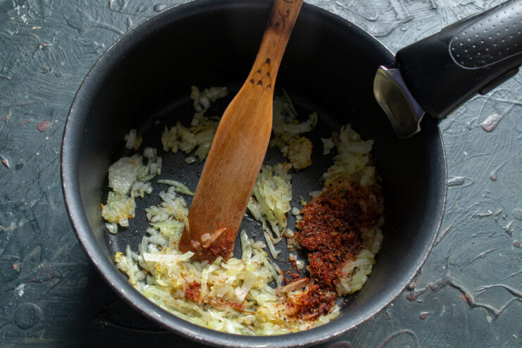 Sautéing the onions Diced onions sautéing with smoked paprika in a heavy-bottomed pot