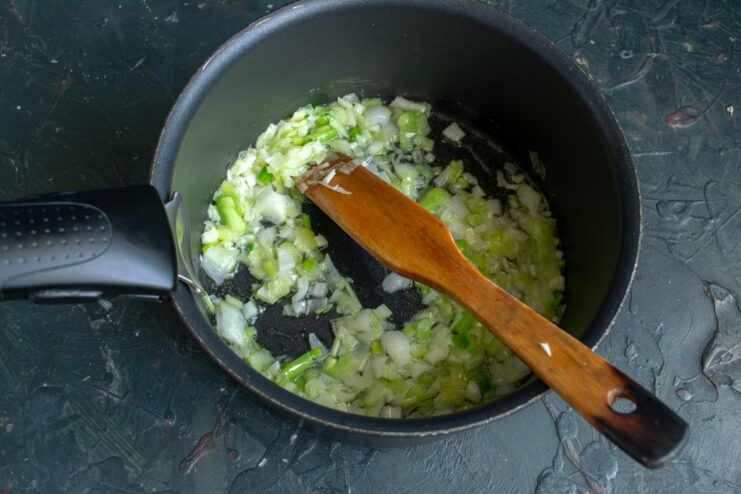 Sauteing finely chopped onions in a pan until soft