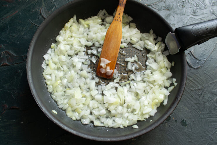 Sautéing the Onions Finely chopped onions cooking in a skillet until translucent