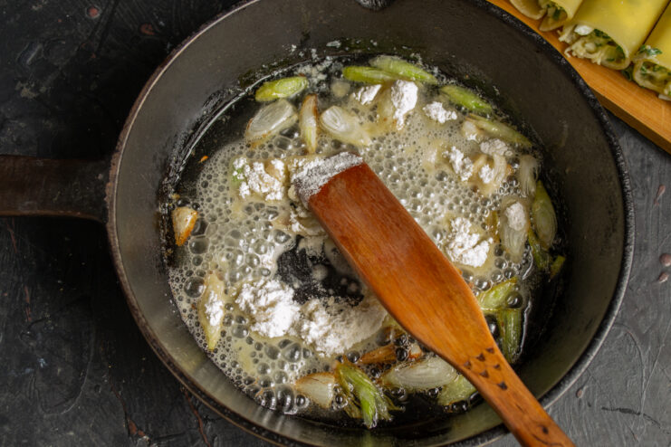 Toasting flour for the roux Flour stirred into sautéed onions in a skillet