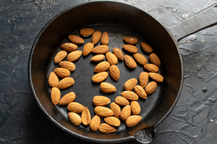 Toasting the raw almonds Toasting whole raw almonds in a cast-iron skillet over low heat until fragrant