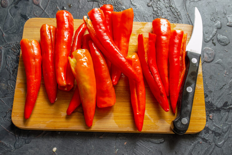 Cleaned chili peppers Seeded chili pepper pods resting on a wooden cutting board