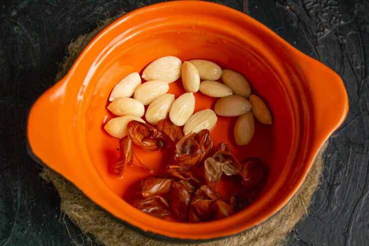 Peeling the almonds Peeled white almonds and brown skins in a bowl.