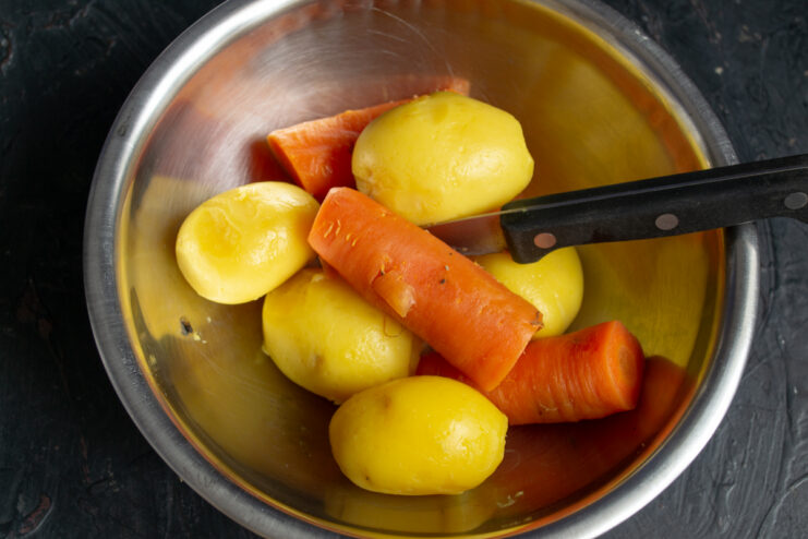 Preparing The Vegetables Boiled potatoes and carrots resting in a metal bowl
