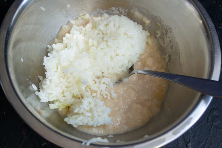 Mixing Ground Chicken And Rice Cooked white rice added to ground chicken mixture in a bowl.