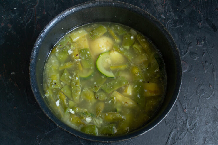 Vegetables simmering in water inside a cooking pot