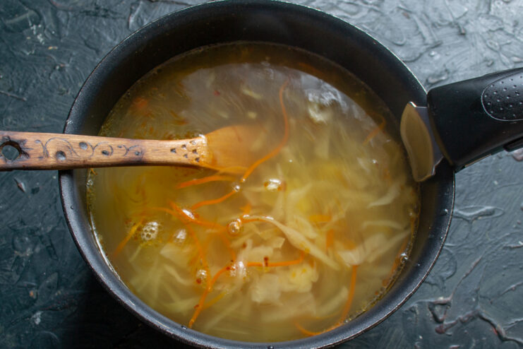 Simmering the vegetable broth Vegetable broth with cabbage and potatoes simmering in a pot