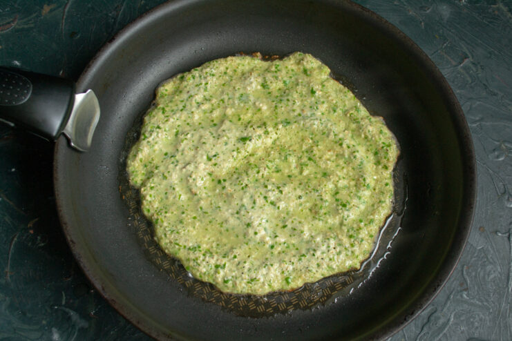 Frying the oat crepe Spinach oat crepe cooking in a skillet