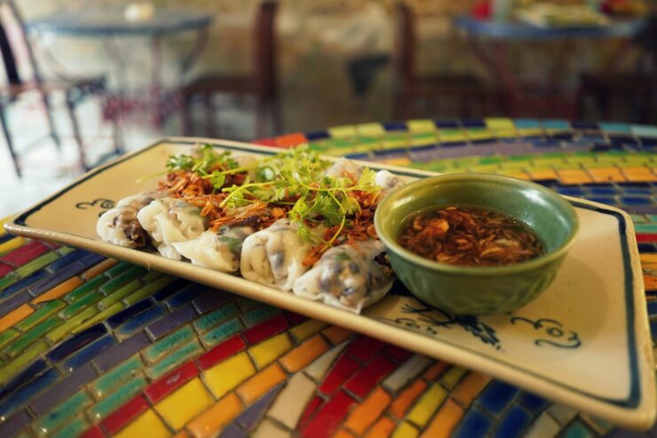 Delicate steamed banh cuon rice rolls Steamed banh cuon rice rolls topped with crispy fried shallots and dipping sauce.