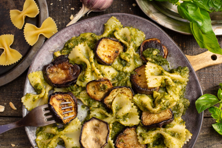 Pasta with fried eggplant and homemade pesto sauce served on a dark plate