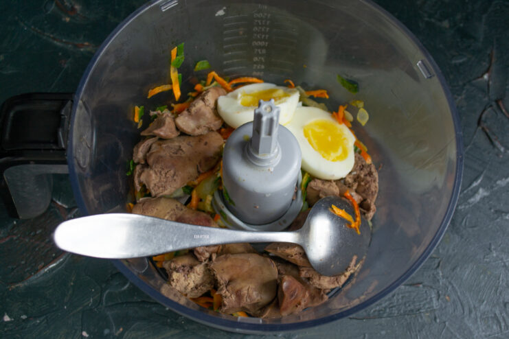 Combining the ingredients Boiled liver, sautéed vegetables, and a boiled egg placed in a blender jar.