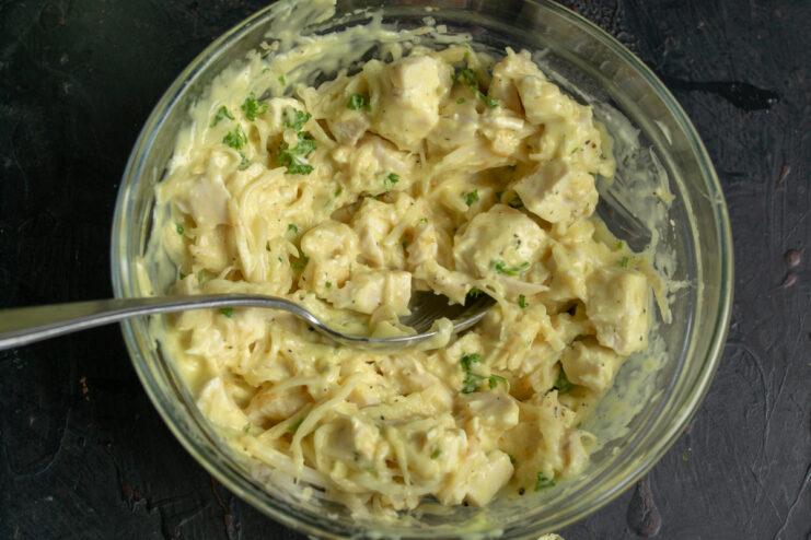 Mixing the salad thoroughly Mixed chicken and celery salad in a bowl ready to be chilled
