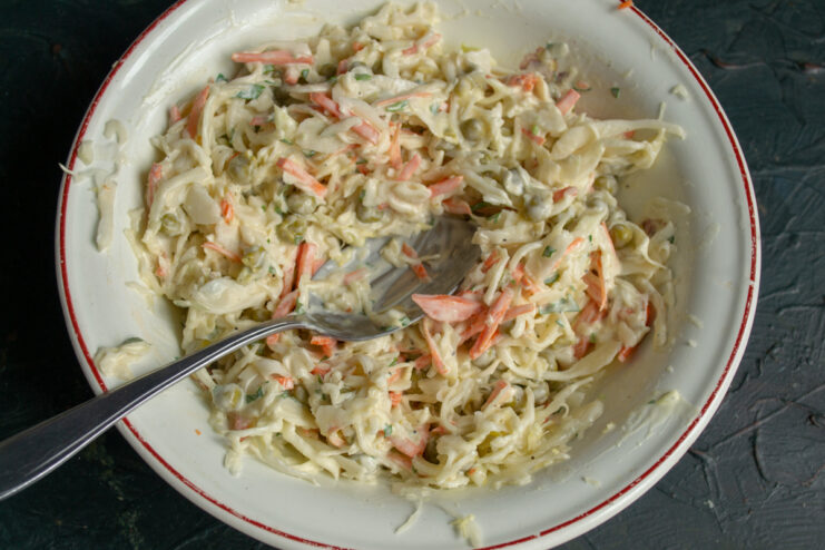 Tossing the salad ingredients Tossed vegetable salad with creamy vegan dressing in a mixing bowl