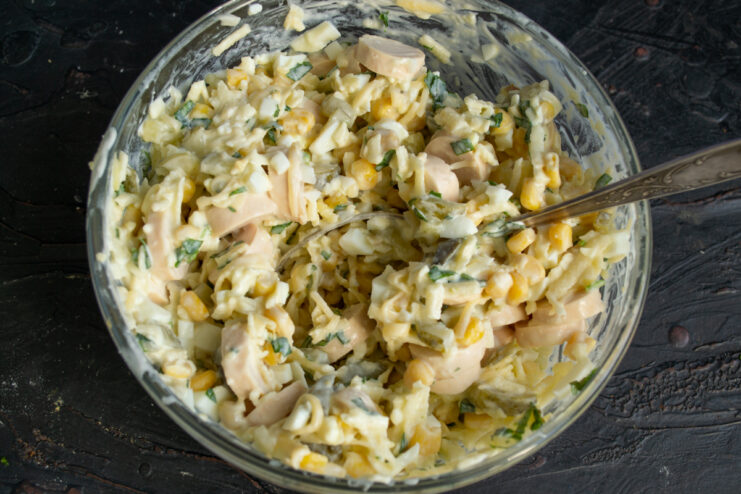 Mixing the salad Mixed sausage salad in a glass bowl.