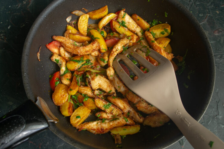 The final cooking stage Stirring the finished chicken ojakhuri with a spatula