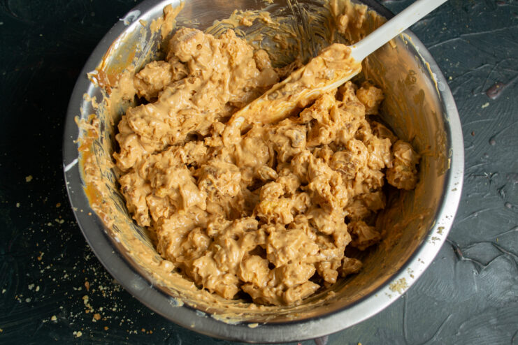 Mixing the ingredients Folding cookie crumbs into frosting using a spatula