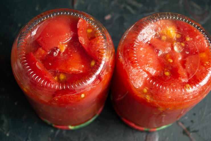 Cooling the finished upside-down jars Upside-down jars of canned tomatoes cooling under a warm towel