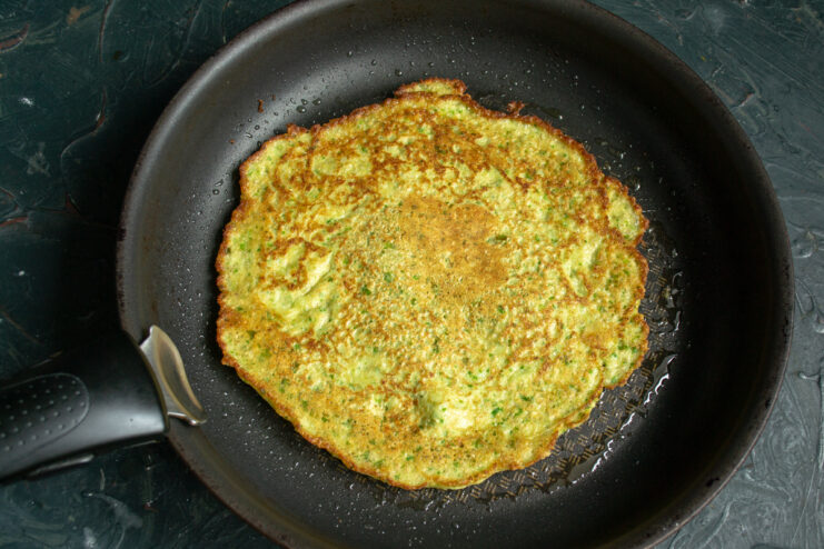 Golden brown oat crepe Flipped oat crepe frying in a pan