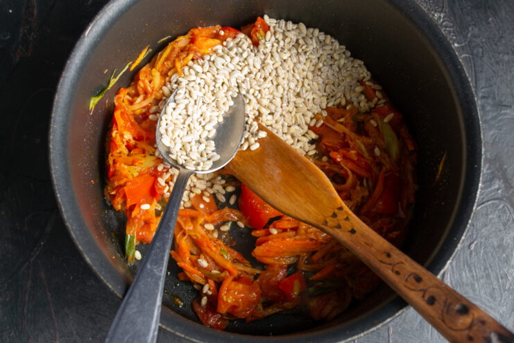Adding Pearl Barley Pearl barley added to the vegetable base in the pot.