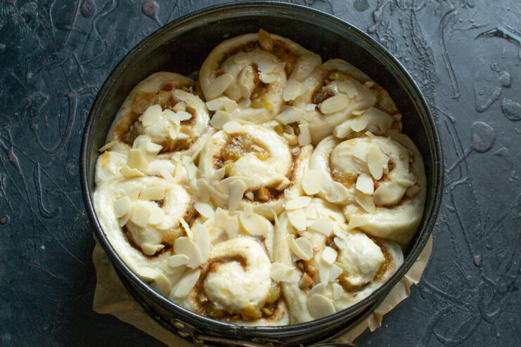 Garnishing with sliced almonds Sprinkling handfuls of sliced almonds evenly over the unbaked egg-washed pie