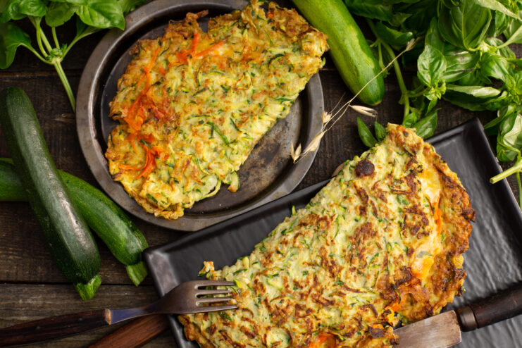 Plated zucchini pockets stuffed with melted cheese and fresh basil.