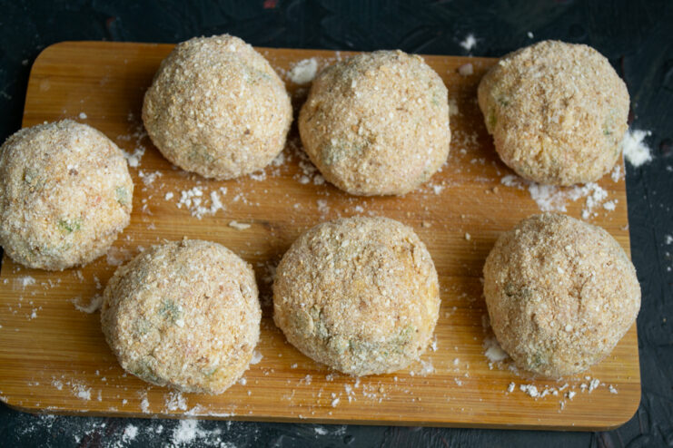 Croquettes before frying Prepared breaded crab croquettes resting on a board