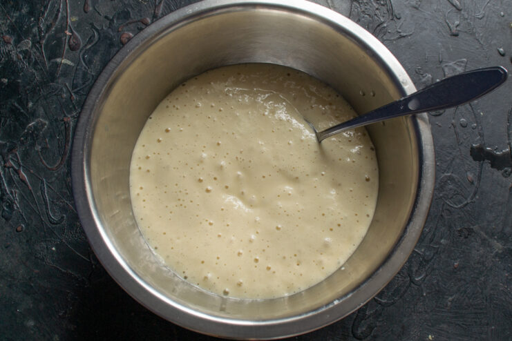 Risen yeast batter with air bubbles in a bowl