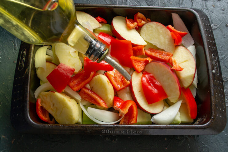 Drizzling with oil Pouring vegetable oil over the chopped vegetables from a bottle