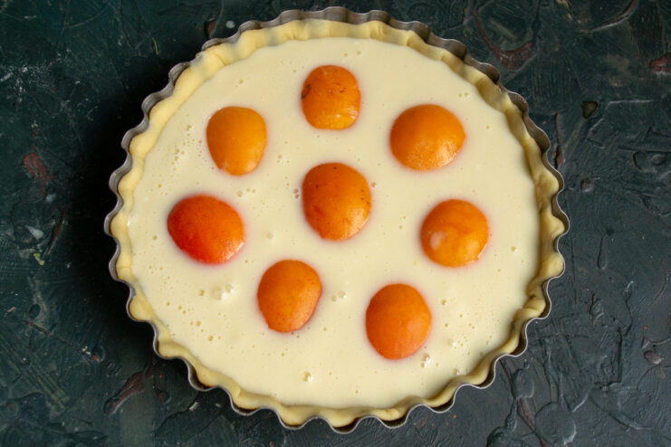 Arranging the apricots Apricot halves arranged cut-side down in the creamy tart filling