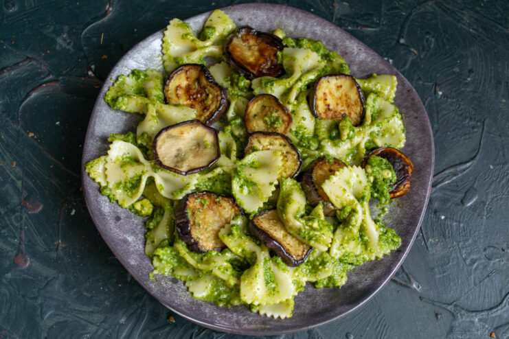 Ready to serve A portion of fresh pasta with eggplant and pesto sprinkled with cheese
