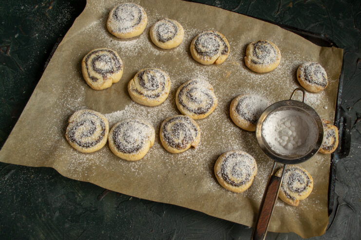 Dusting With Sugar Dusting hot baked cookies with powdered sugar through a fine sieve