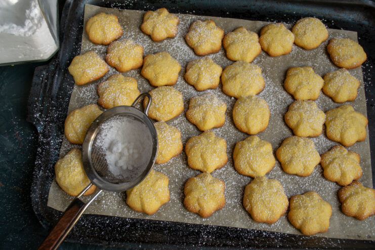 Dusting with powdered sugar Dusting freshly baked polenta cookies with powdered sugar through a fine sieve.