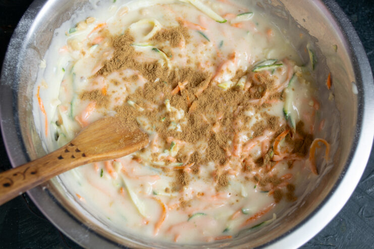 Sprinkling ground cinnamon over the cake batter