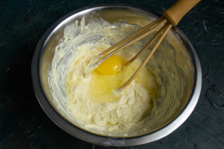 Mixing the dough base Whisking butter with sugar and an egg in a mixing bowl