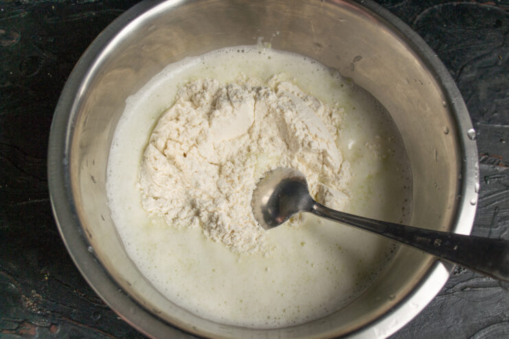 Sifting all-purpose flour into a mixing bowl with zucchini puree