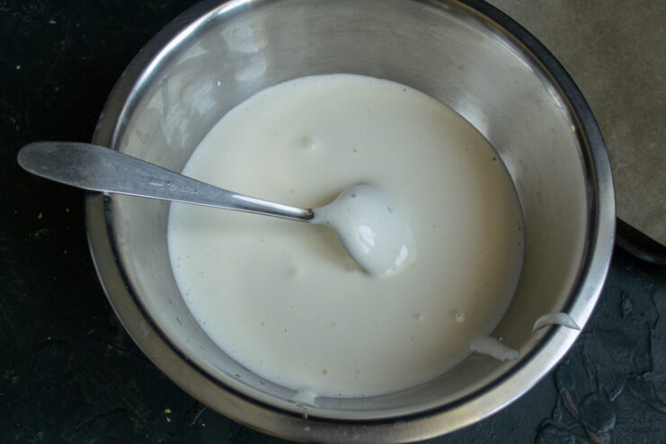 Pouring the whipped egg base. Fluffy whipped egg and sugar mixture in a metal mixing bowl.