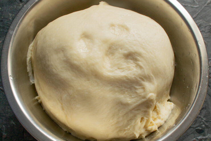 Risen yeast dough doubled in volume inside a clean bowl