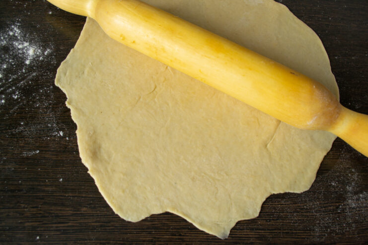 Rolling Out the Dough Rolling out shortcrust pastry with a rolling pin on a floured table