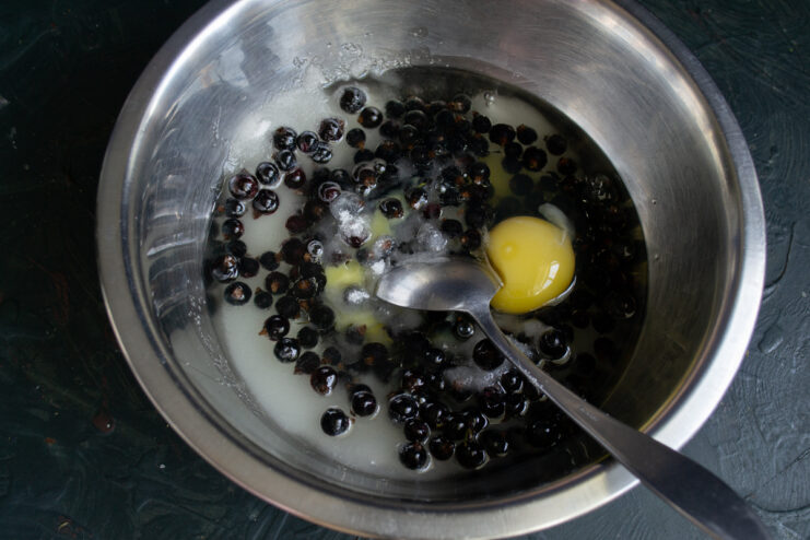 Pouring The Vegetable Oil Pouring vegetable oil into a bowl with berries and eggs