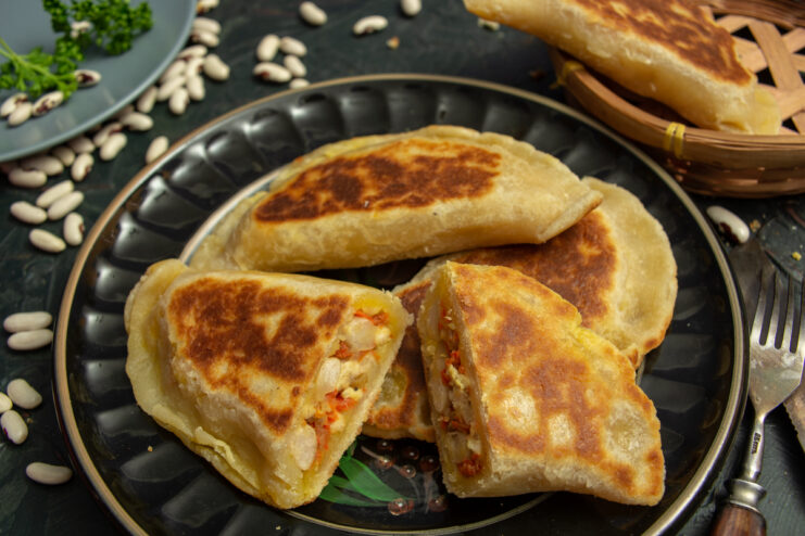 Cross-section of a pan-fried hand pie showing chicken, beans, and vegetables