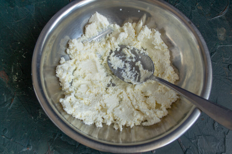 Ricotta cheese in a metal mixing bowl