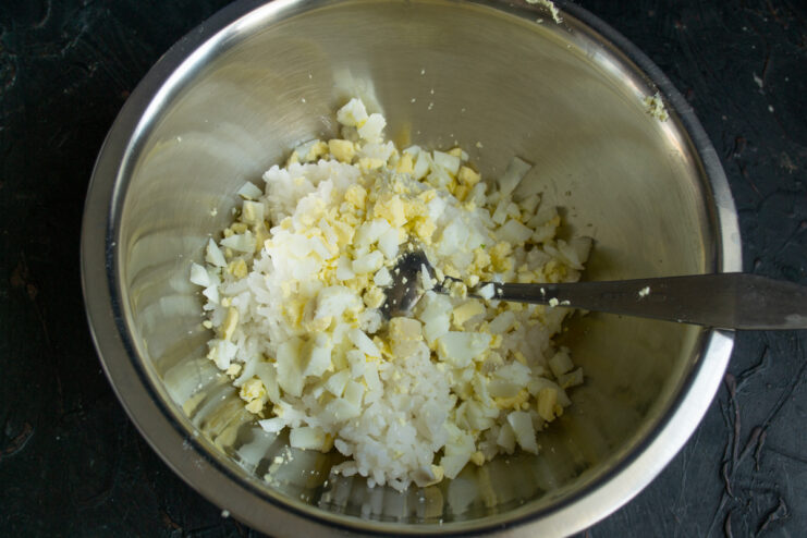Adding eggs to the rice White rice mixed with finely chopped hard-boiled eggs
