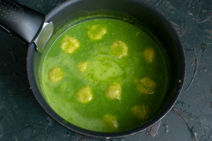 Rice dumplings boiling and floating in the green soup