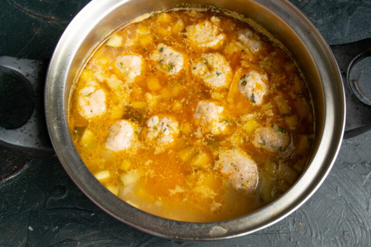 Poaching the fish meatballs Fish meatballs poaching in the gently simmering rassolnik