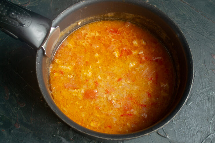 Simmering the soup before blending Fish soup with vegetables and salmon simmering in a pot before blending