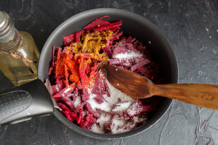 Seasoning the borsch base Salt, sugar, and spices sprinkled over the vegetable mixture.