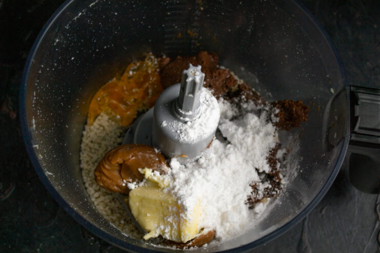 Powdered sugar for thickness Powdered sugar added on top of the nut mixture in a blender.